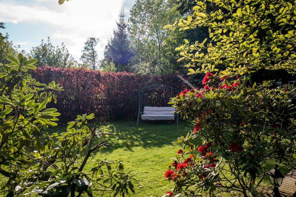 Gardening in Raleigh: a cushioned bench swing surrounded by vibrant flowers