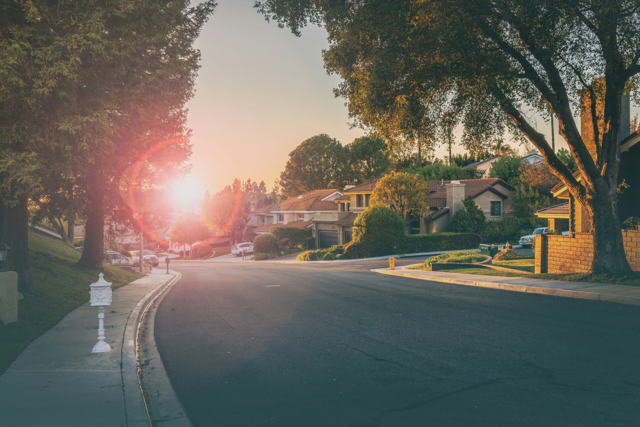 Peaceful suburban street at sunset, similar to neighborhoods that make you think of Fuquay-Varina vs Holly Springs, North Carolina